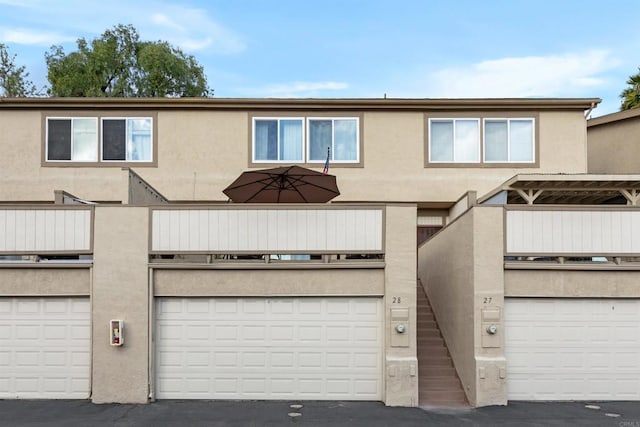 view of property featuring a garage and stucco siding