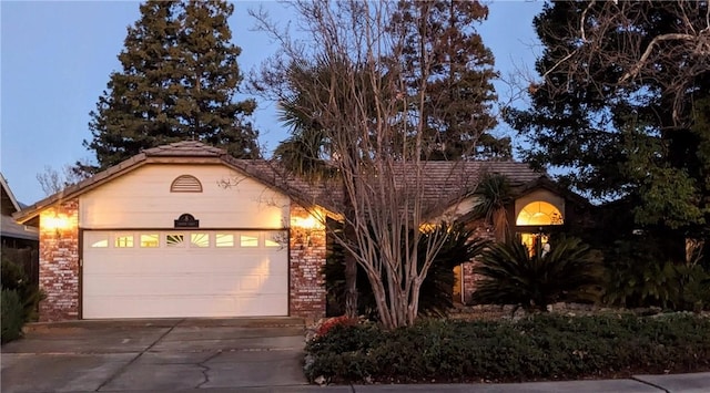 view of front facade featuring a garage, brick siding, and driveway