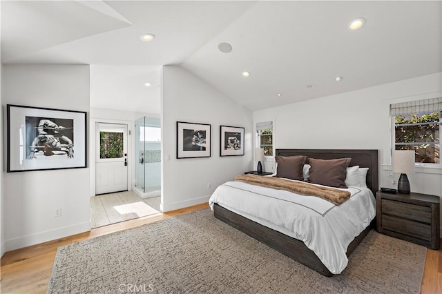 bedroom featuring multiple windows, vaulted ceiling, and light wood-type flooring