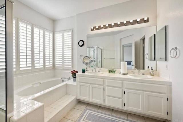 bathroom featuring vanity, plus walk in shower, and tile patterned flooring