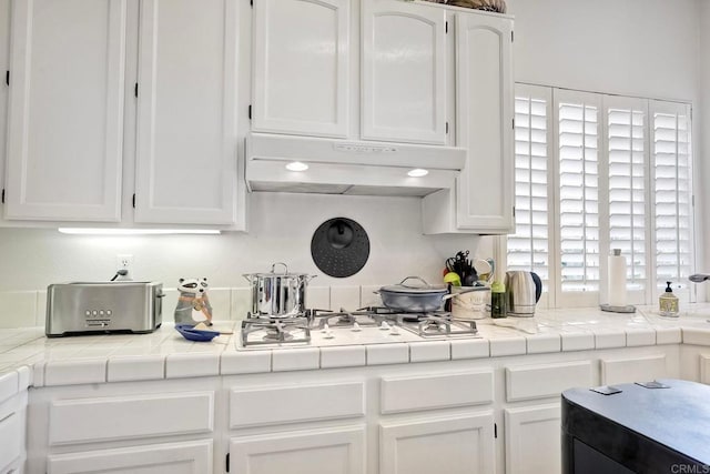 kitchen with white cabinetry, tile counters, and white gas stovetop