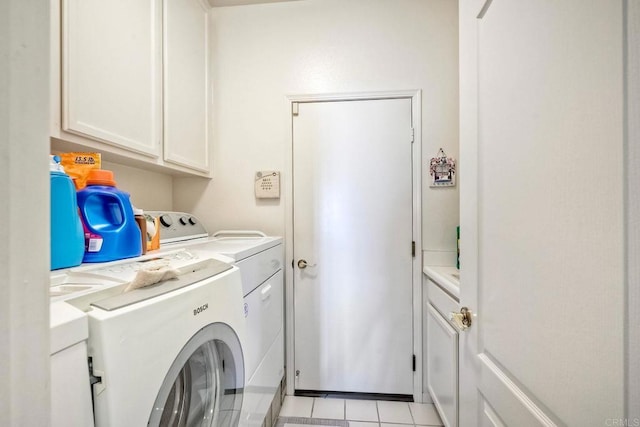 laundry area featuring cabinets, washing machine and clothes dryer, and light tile patterned flooring