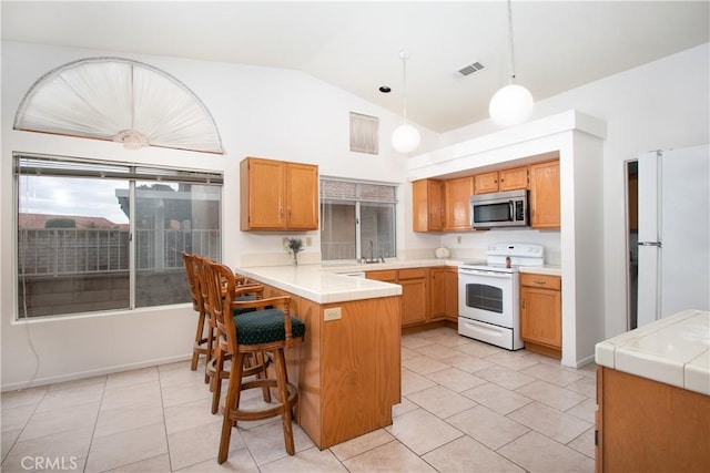 2869 Maple Dr, Hemet, CA 92545 - kitchen with white appliances, a peninsula, light tile patterned floors, hanging light fixtures, and a kitchen bar