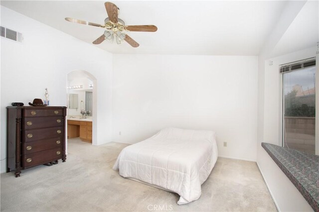 2869 Maple Dr, Hemet, CA 92545 - bedroom with vaulted ceiling, light colored carpet, arched walkways, ensuite bath, and a ceiling fan