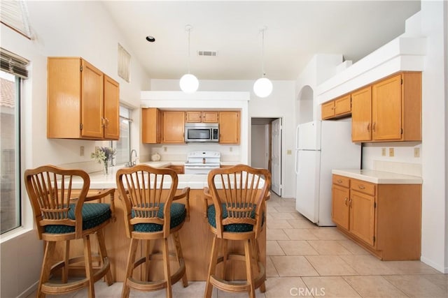 2869 Maple Dr, Hemet, CA 92545 - kitchen featuring white appliances, a peninsula, light countertops, hanging light fixtures, and light tile patterned floors