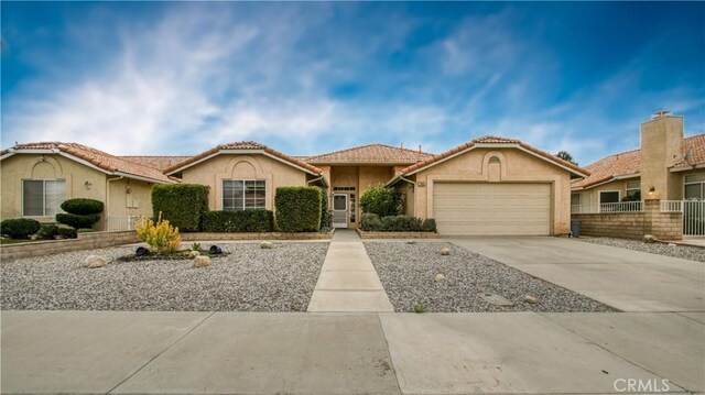 2869 Maple Dr, Hemet, CA 92545 - mediterranean / spanish-style house featuring an attached garage, stucco siding, and driveway