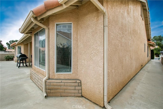 2869 Maple Dr, Hemet, CA 92545 - view of side of property featuring stucco siding, a patio, and fence