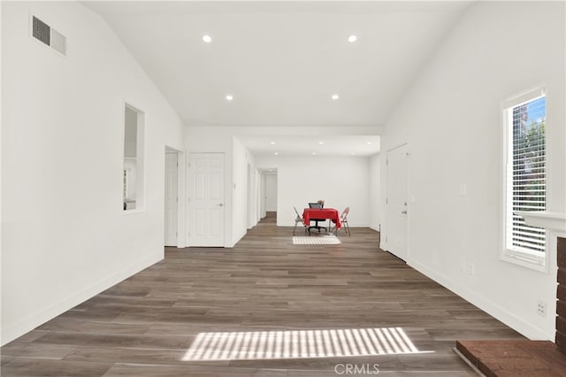 hallway with dark hardwood / wood-style flooring and high vaulted ceiling