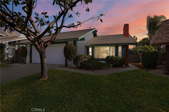 ranch-style house featuring a garage and a lawn