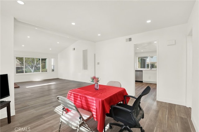 dining area with light hardwood / wood-style flooring and vaulted ceiling