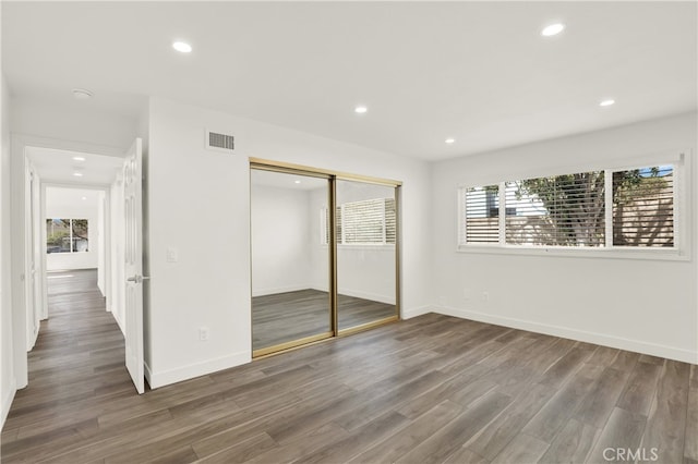 unfurnished bedroom featuring a closet and dark hardwood / wood-style floors