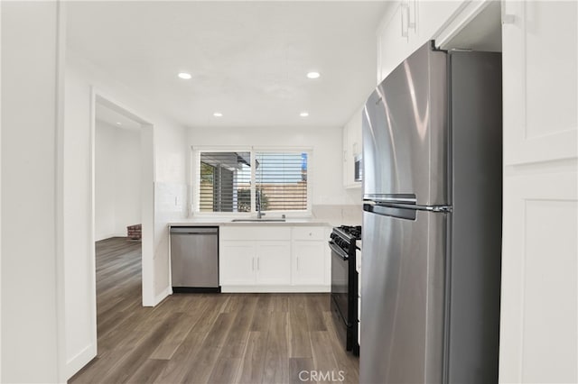 kitchen with dark wood-type flooring, stainless steel appliances, sink, and white cabinets