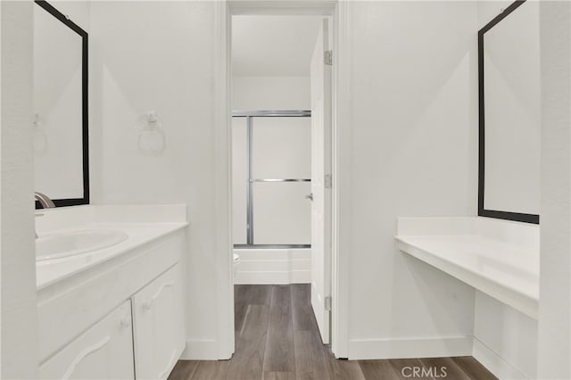 full bathroom with vanity, hardwood / wood-style floors, shower / bath combination with glass door, and toilet