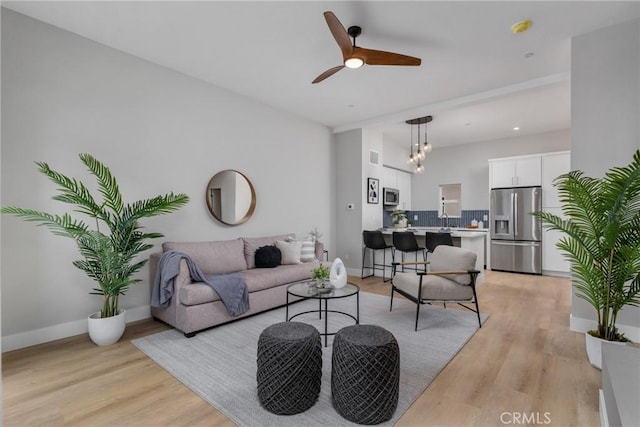 living room with ceiling fan and light wood-type flooring