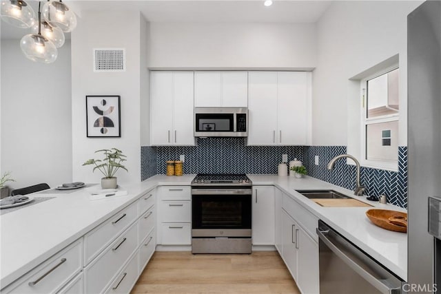 kitchen featuring sink, stainless steel appliances, and white cabinets