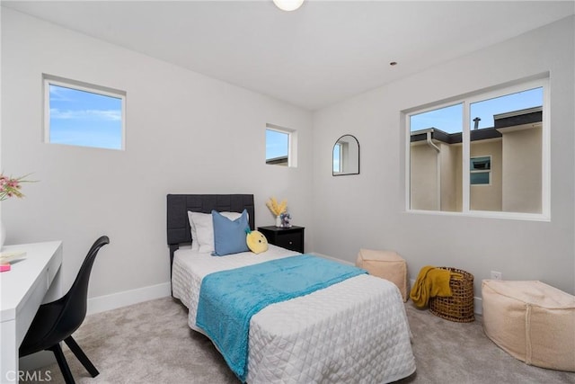 bedroom with light colored carpet and multiple windows