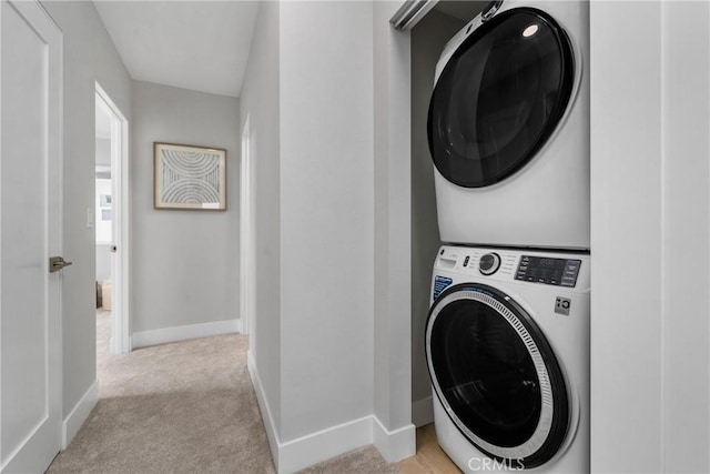 washroom featuring stacked washer / dryer and light colored carpet