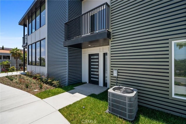 property entrance featuring a balcony and central AC unit