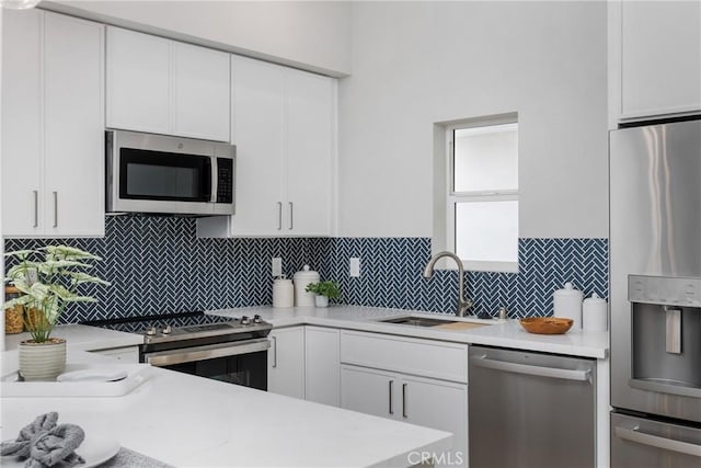 kitchen with backsplash, stainless steel appliances, sink, and white cabinets