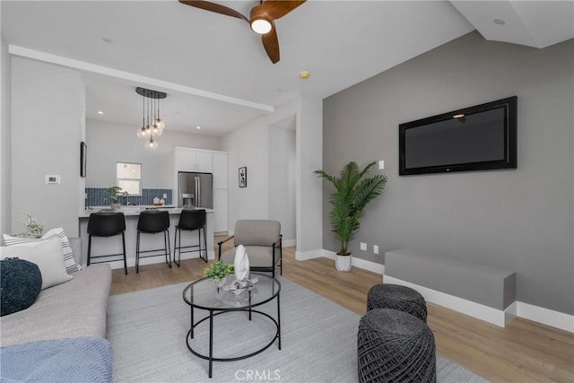 living room with ceiling fan and light hardwood / wood-style flooring