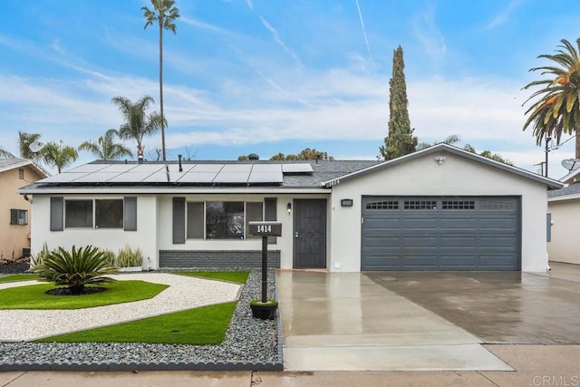 ranch-style home with a garage and solar panels