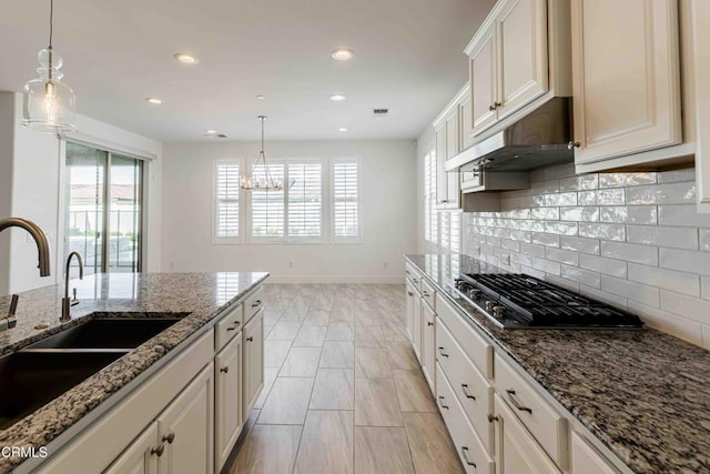14706 Pemberley Passage Ave, Bakersfield, CA 93311 - kitchen with sink, stainless steel gas cooktop, hanging light fixtures, and stone countertops