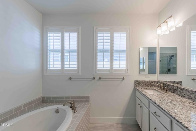 14706 Pemberley Passage Ave, Bakersfield, CA 93311 - bathroom with a healthy amount of sunlight, tiled bath, and vanity