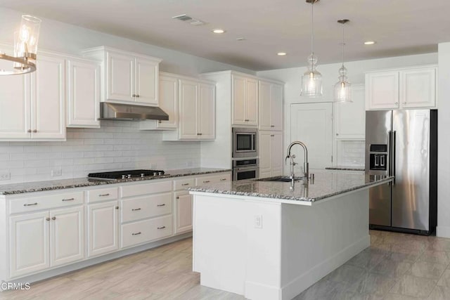 14706 Pemberley Passage Ave, Bakersfield, CA 93311 - kitchen featuring white cabinetry, a center island with sink, dark stone countertops, pendant lighting, and stainless steel appliances