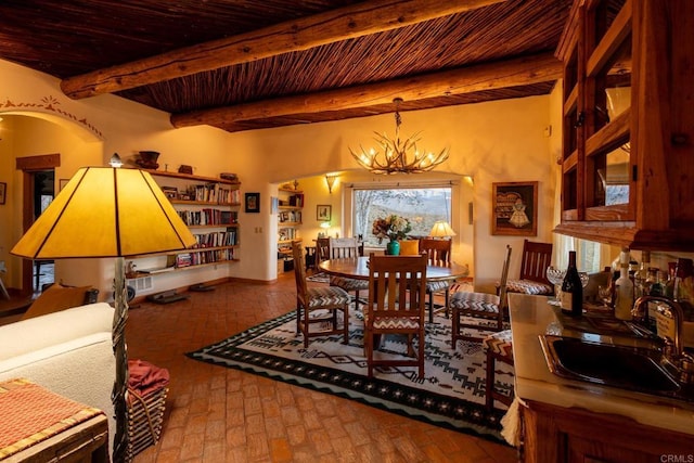 dining space featuring arched walkways, brick floor, wood ceiling, beam ceiling, and an inviting chandelier