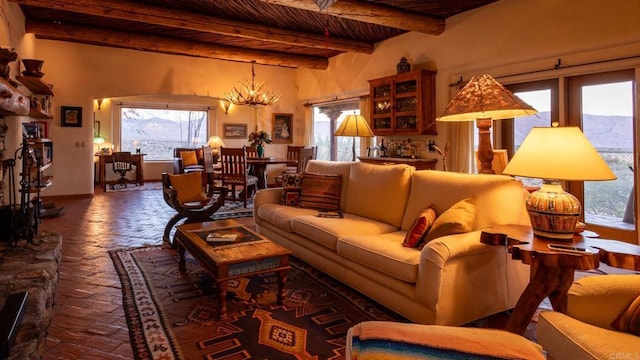 living room with a notable chandelier, wooden ceiling, plenty of natural light, and beamed ceiling