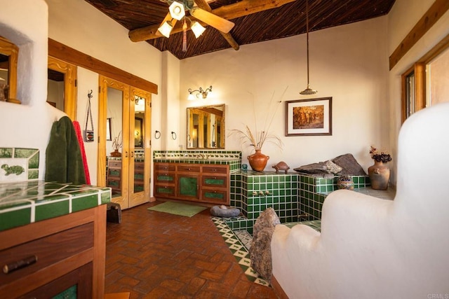 bathroom featuring a ceiling fan, wooden ceiling, beamed ceiling, brick floor, and vanity