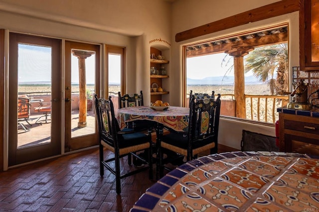 dining room featuring brick floor and a mountain view