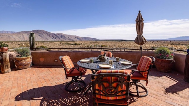 view of patio with outdoor dining area and a mountain view