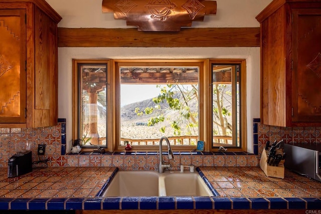 kitchen with tasteful backsplash, dark countertops, and a sink