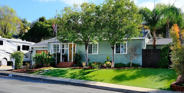 view of property hidden behind natural elements with a garage and a front yard