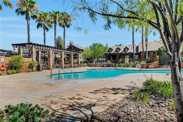 community pool featuring a pergola, fence, and a patio area