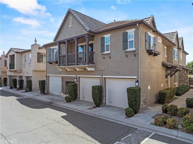 exterior space featuring an attached garage, driveway, stucco siding, and a tile roof