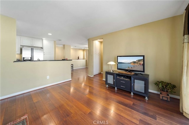 unfurnished living room with recessed lighting, baseboards, and dark wood finished floors