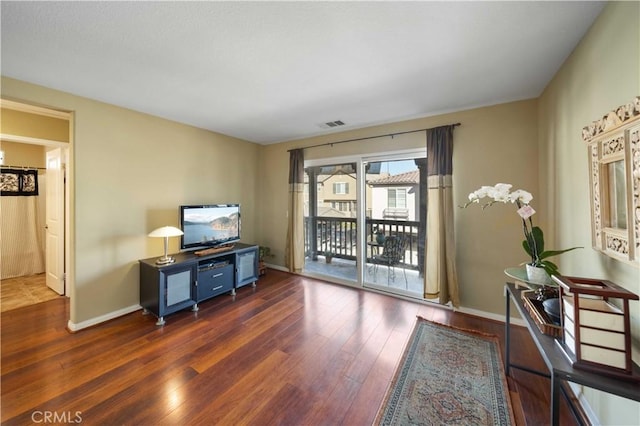 living area with visible vents, baseboards, and hardwood / wood-style flooring