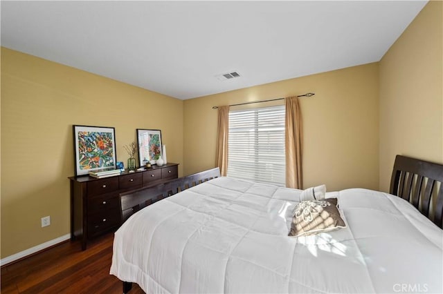 bedroom featuring visible vents, baseboards, and dark wood-style flooring