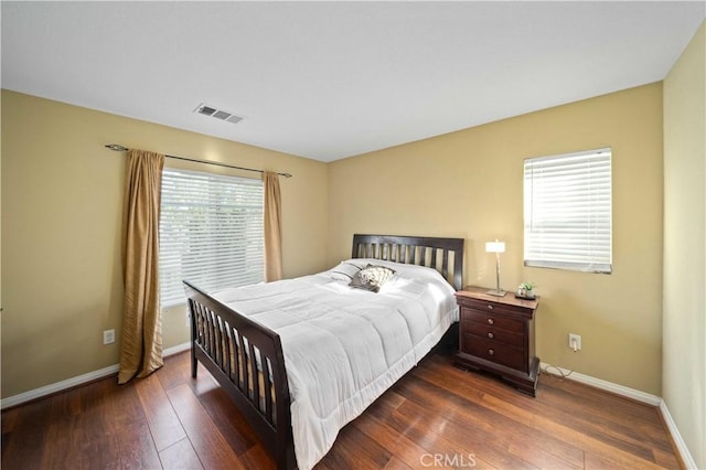 bedroom featuring visible vents, baseboards, and hardwood / wood-style floors