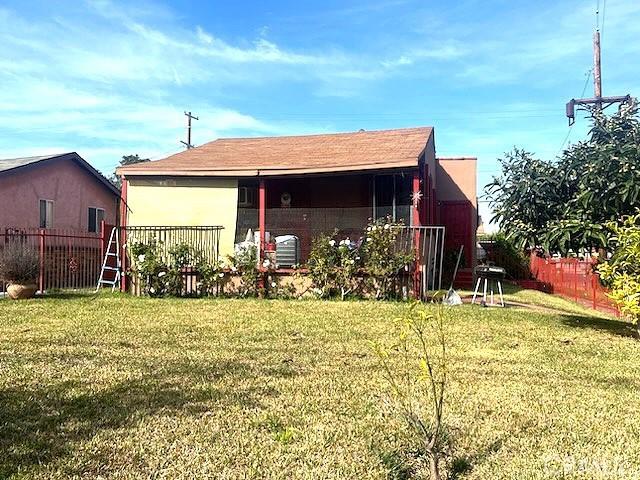 back of house with a lawn and fence