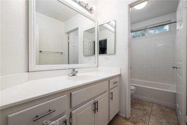 full bathroom featuring tiled shower / bath, vanity, and toilet