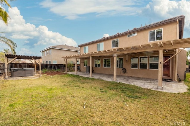 rear view of property featuring a yard, a pergola, a hot tub, and a patio