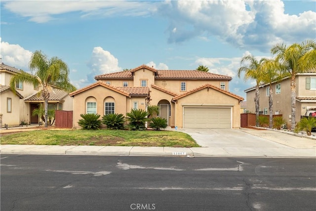 mediterranean / spanish home featuring a garage and a front lawn