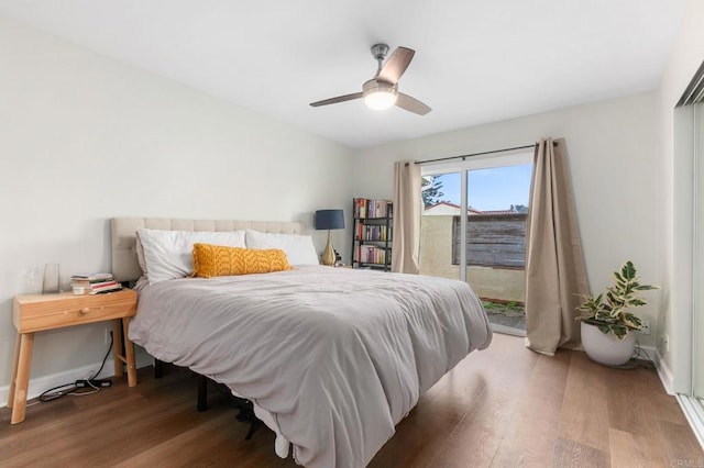 bedroom with access to exterior, hardwood / wood-style floors, and ceiling fan