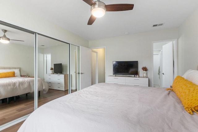 bedroom featuring ceiling fan, dark hardwood / wood-style flooring, and a closet