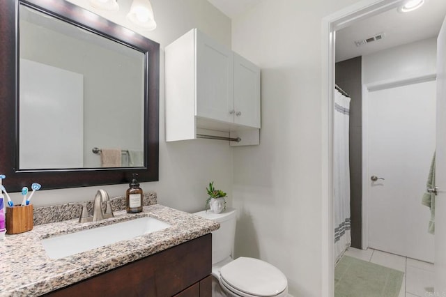 bathroom featuring vanity, tile patterned floors, and toilet