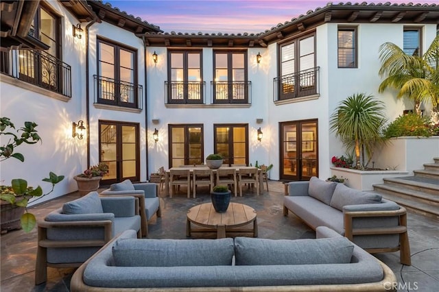 212 John St, Manhattan Beach, CA 90266 - back of house at dusk featuring outdoor dining space, stucco siding, outdoor lounge area, french doors, and a patio area