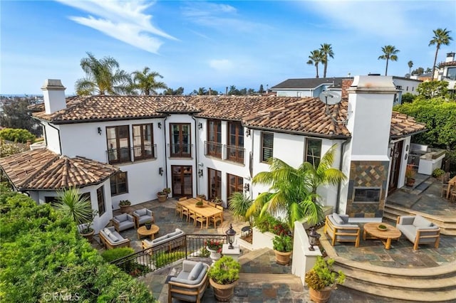 rear view of house with an outdoor living space and a patio area